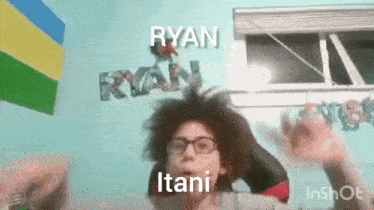 a person with glasses is standing in front of a wall with the word ryan on it