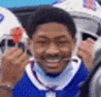 a man in a blue shirt is holding a red card and smiling