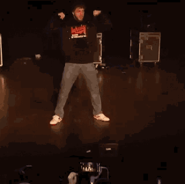 a man wearing a jahmy sweatshirt is dancing on stage