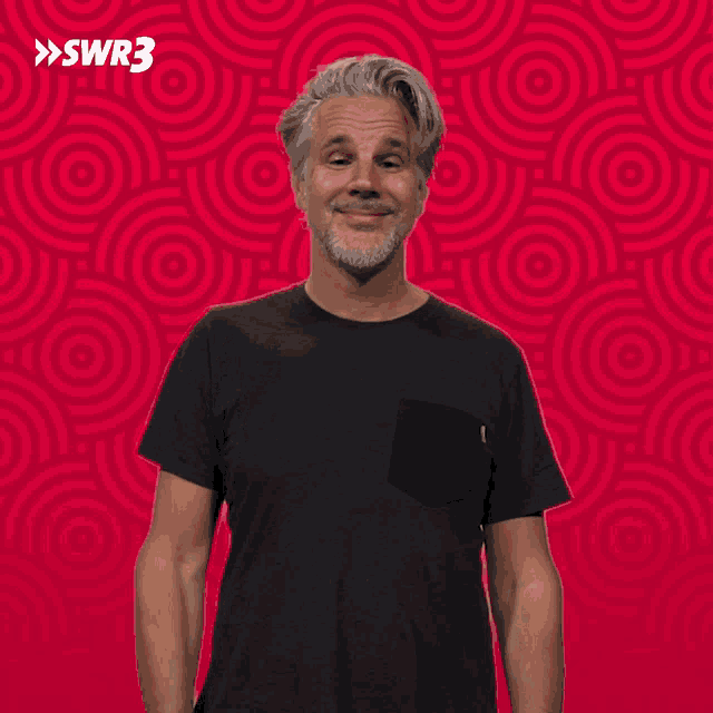 a man waving his hand in front of a red background with swr3 written on it