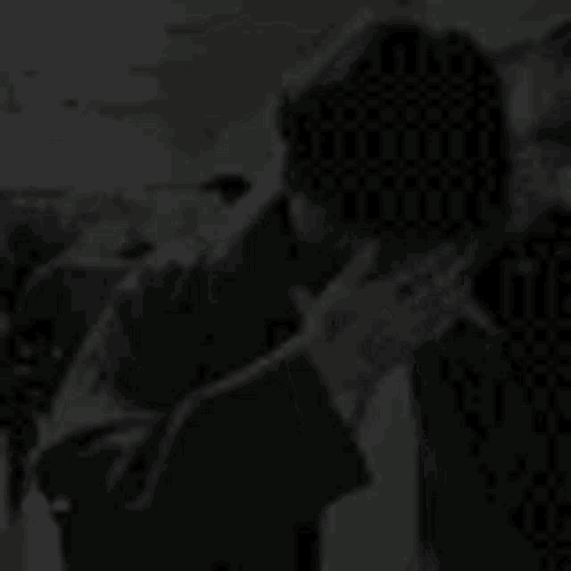 a black and white photo of a man kissing another man .