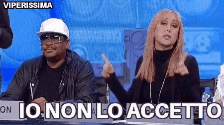 a man and a woman are sitting at a table with io non lo accetto written on the bottom