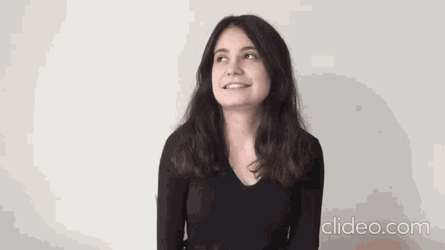 a woman is smiling and looking at the camera .