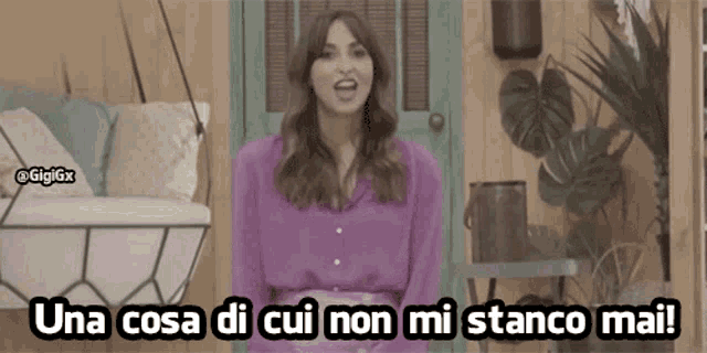 a woman in a purple shirt is standing in front of a swing and says una cosa di cui non mi stanco mai