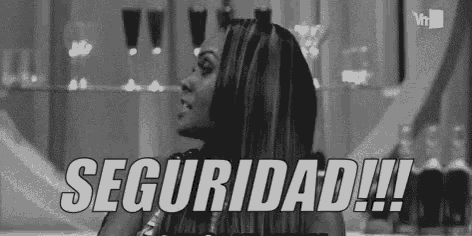 a black and white photo of a woman standing in front of a glass wall with the words seguridad written on it .