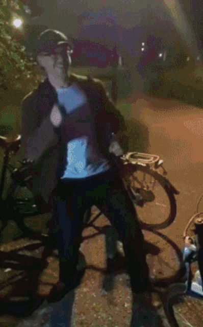 a man wearing a hat and a white shirt is standing in front of a bicycle
