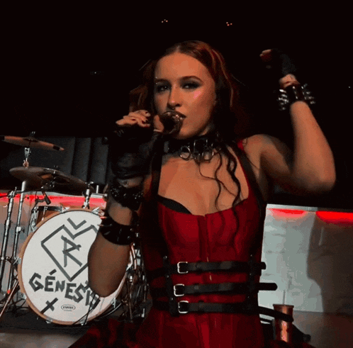 a woman stands in front of a drum that says genesis on it
