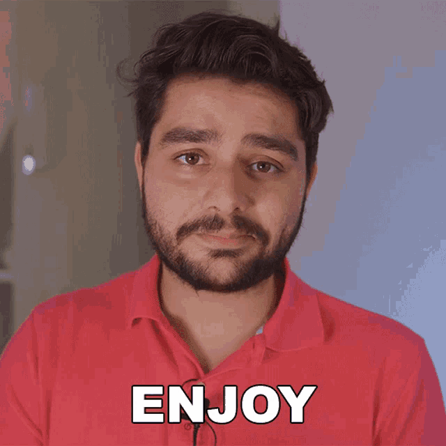 a man with a beard is wearing a red shirt with the word enjoy written on it