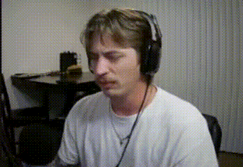 a man wearing headphones and a white shirt is sitting in front of a computer .