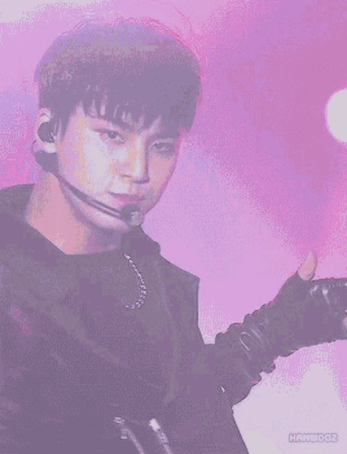 a close up of a man wearing a microphone and gloves with hanwooz written on the bottom
