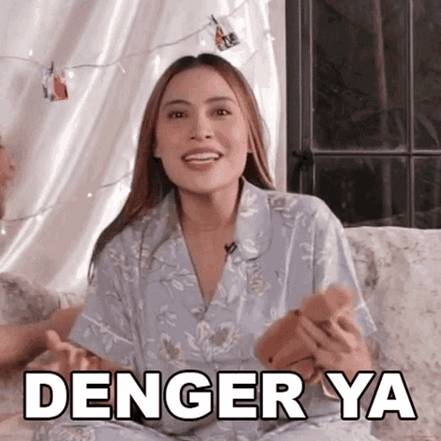 a woman in pajamas is sitting on a couch with the words denger ya written above her