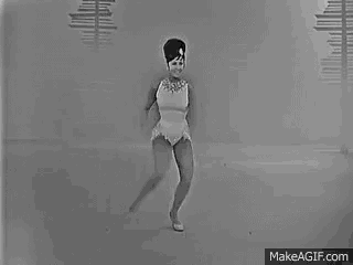 a black and white photo of a woman in a white dress dancing on ice .