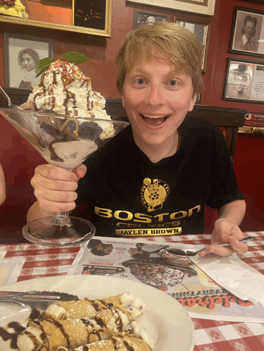 a boy wearing a boston shirt is holding a giant ice cream cone