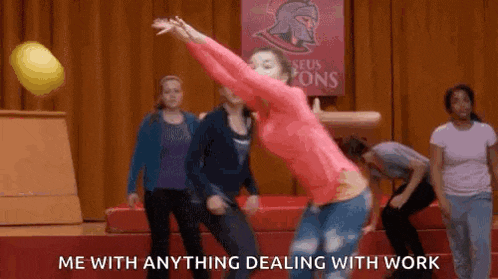 a woman in a pink shirt is throwing a ball in a gym while a group of people watch .