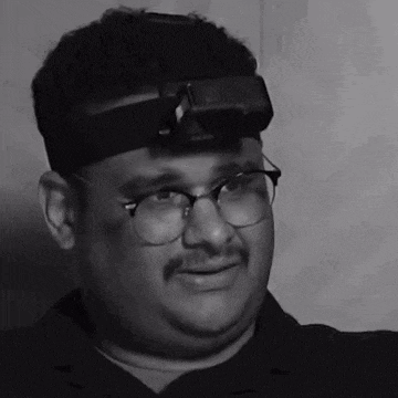a man wearing glasses and a headlight on his head .
