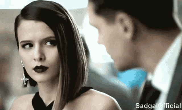 a man and a woman are looking at each other with sadgal official written on the bottom right