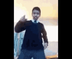 a boy in a suit and tie is dancing in a room