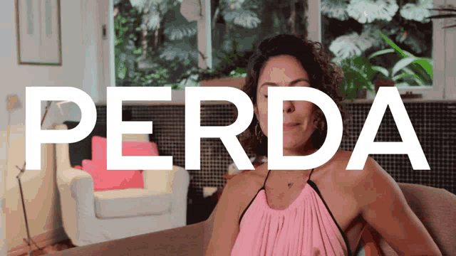 a woman in a pink dress sits on a couch with the word perda behind her