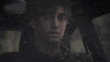 a close up of a man 's face while sitting in a car