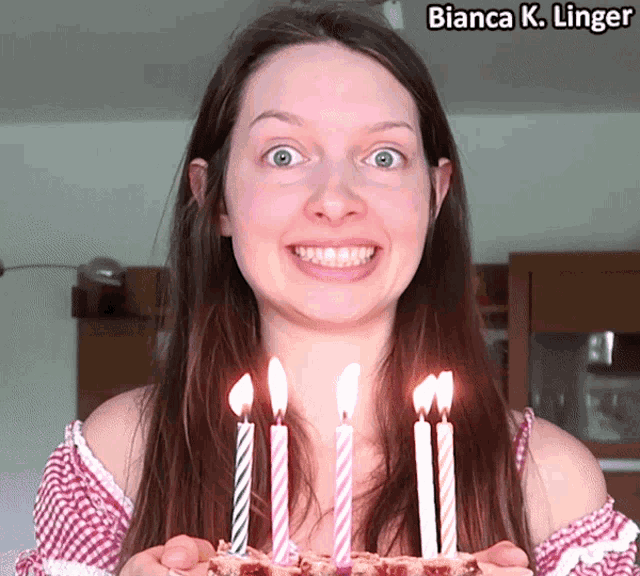 bianca k. linger is holding a birthday cake with candles