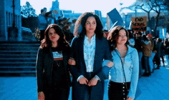 a group of women are walking down a street with a sign that says end sexual violence .