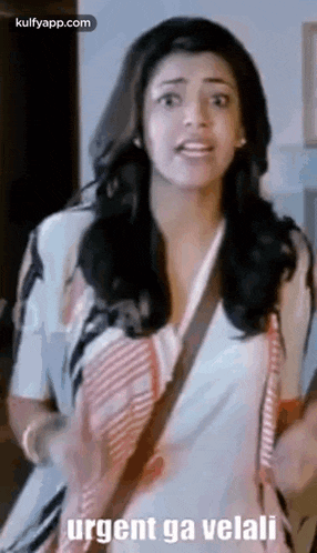 a woman is standing in a room and talking to someone while wearing a white shirt .
