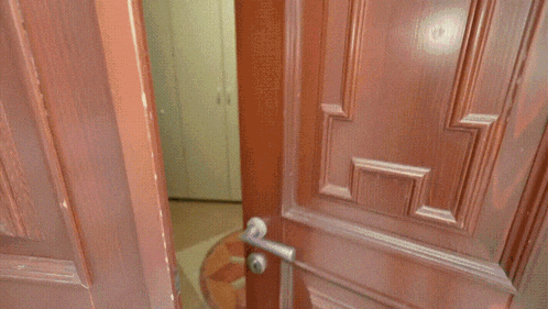 a man is cleaning the floor in front of a door with a greek key design