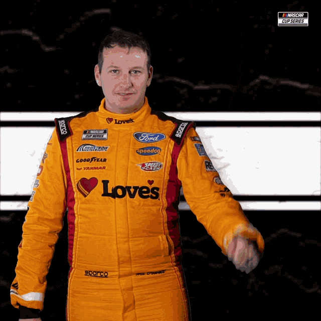 a man in a yellow love 's racing suit is giving a thumbs up
