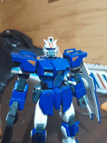 a blue and white robot with a shield and a red head