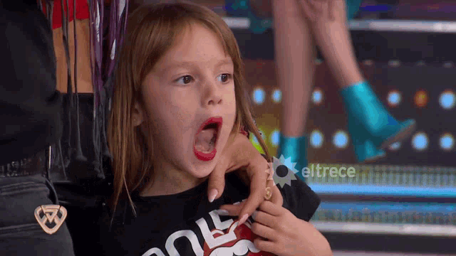 a little girl wearing a black shirt that says " rock "