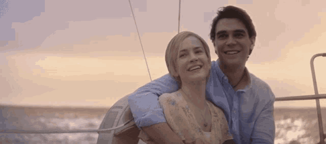 a man and a woman are sitting on a boat in the ocean