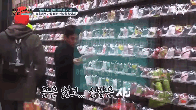 a man in a red hat is standing in front of a display of shoes