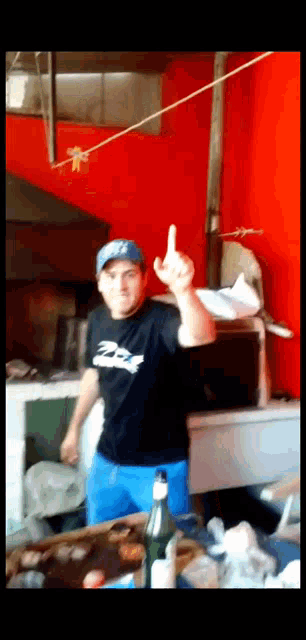 a man wearing a black shirt that says ' racing ' on it is giving the middle finger
