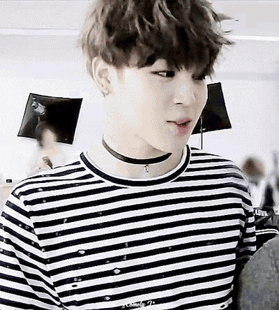 a close up of a person wearing a choker and striped shirt