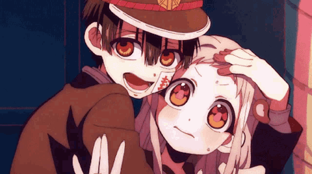 a boy and a girl are standing next to each other and the girl has a card on her face
