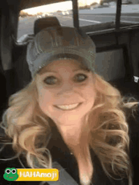 a woman wearing a hat is sitting in the back seat of a car .