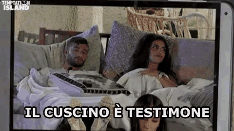 a man and a woman are laying on a couch with their feet up .
