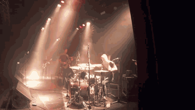 a man playing a drum set on a stage