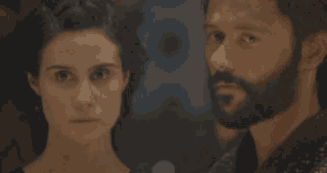 a man with a beard is looking at a woman