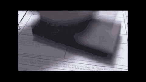 a person is stamping a piece of paper with a black stamp