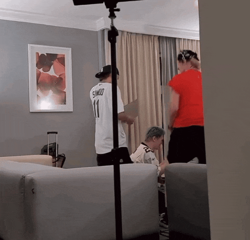 a man wearing a number 11 shirt stands in a living room