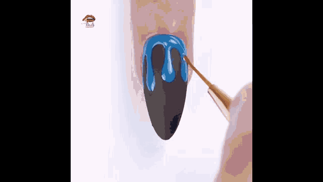 a person is painting their nails with blue and black nail polish .