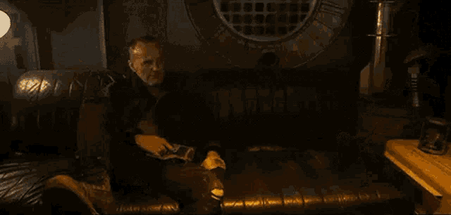 a man and a woman are sitting at a table in a dark room .