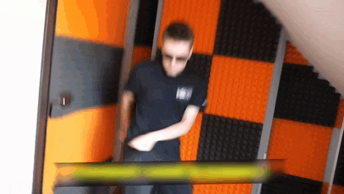 a blurry picture of a man standing in front of an orange wall with a sign that says ' a ' on it