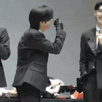 a man in a suit takes a picture of another man