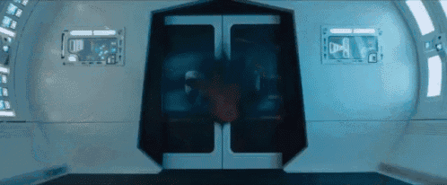 a person is walking through a doorway in a room with a few windows
