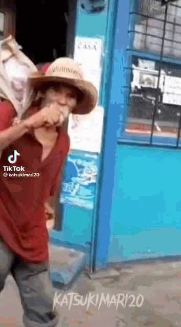 a man wearing a cowboy hat and carrying a bag on his back .