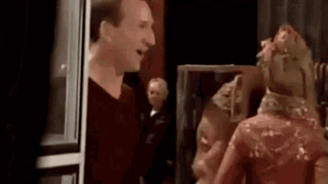 a man is standing next to a woman in a red dress .