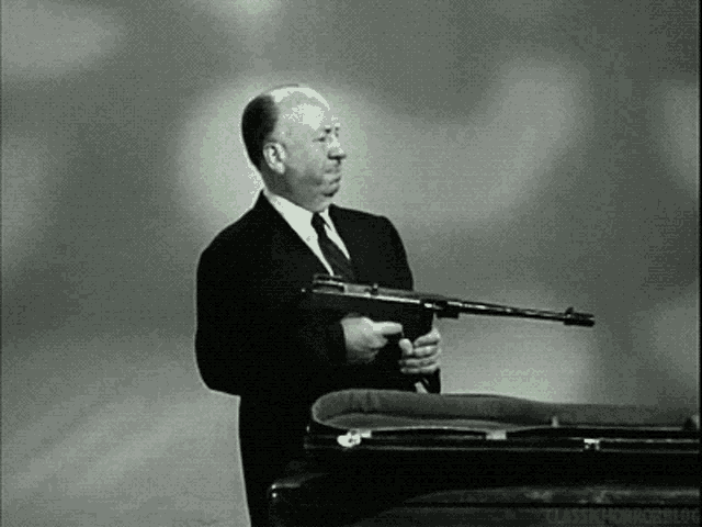 a man in a suit and tie is holding a gun
