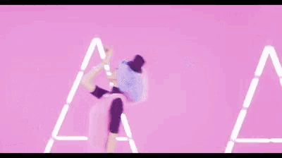 two women are dancing in a pink room .